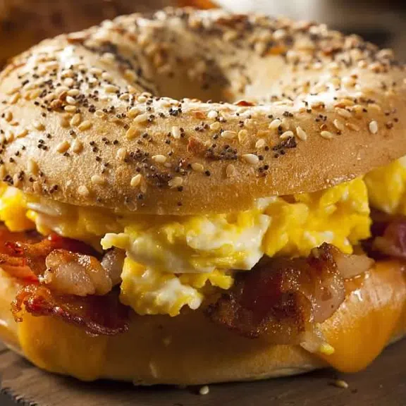 A bagel sandwich with eggs, bacon and cheese