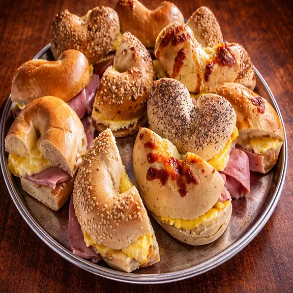 A platter of assorted breakfast bagel sandwich halves